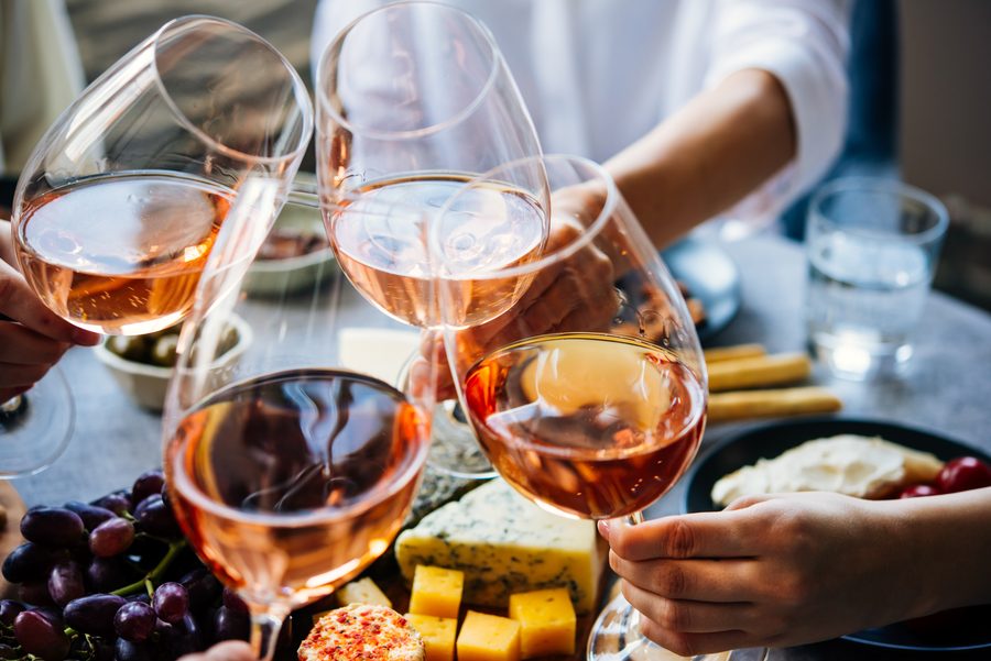 Guests toasting with ros&eacute; over a grazing board at a corporate event